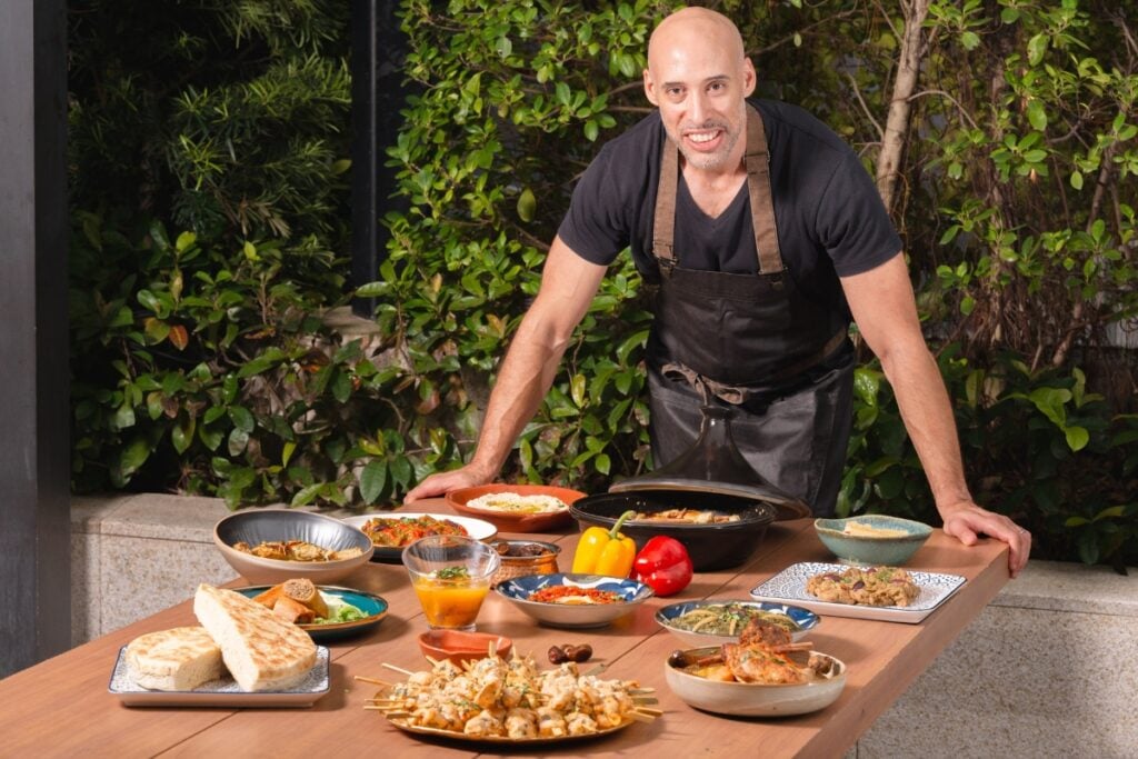 Hakim Meddour takes North African home comforts to Hong Kong with catering company Kendira Hakim Meddour on table smiling Kendira catering